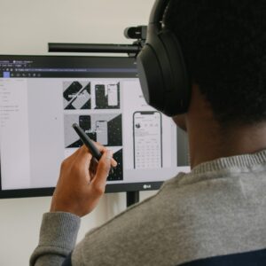 man in gray sweater holding black smartphone